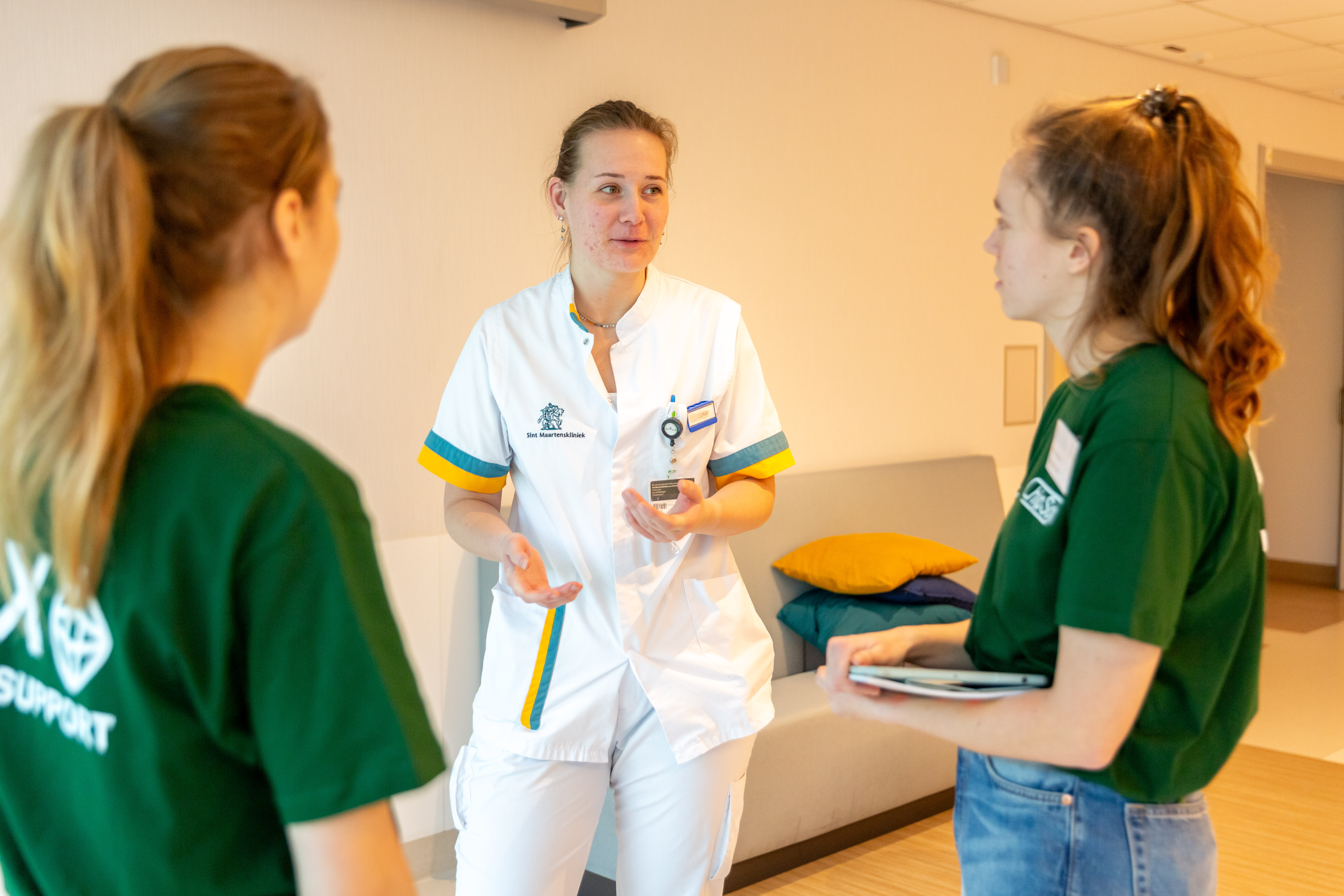 Young KINASE-medewerker begeleidt een zorgverlener op de werkvloer
