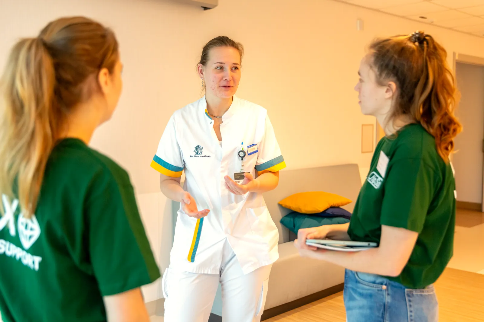 Young KINASE-medewerker begeleidt een zorgverlener op de werkvloer