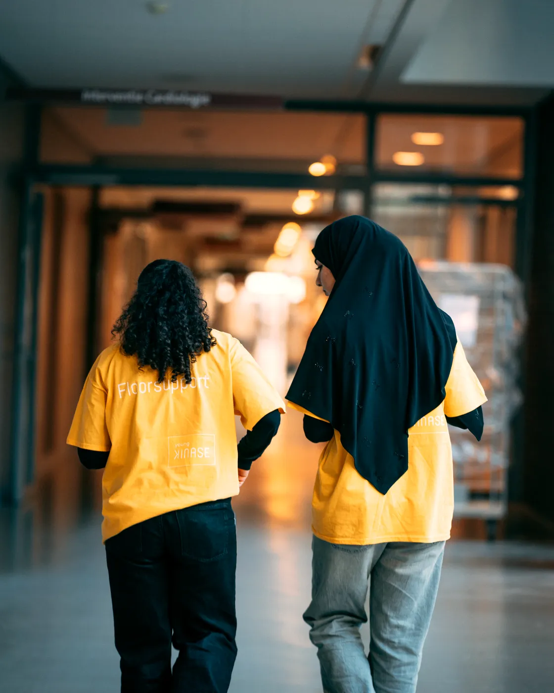 Twee floorsupporters van Young KINASE lopen samen over de ziekenhuisgang tijdens een go-live