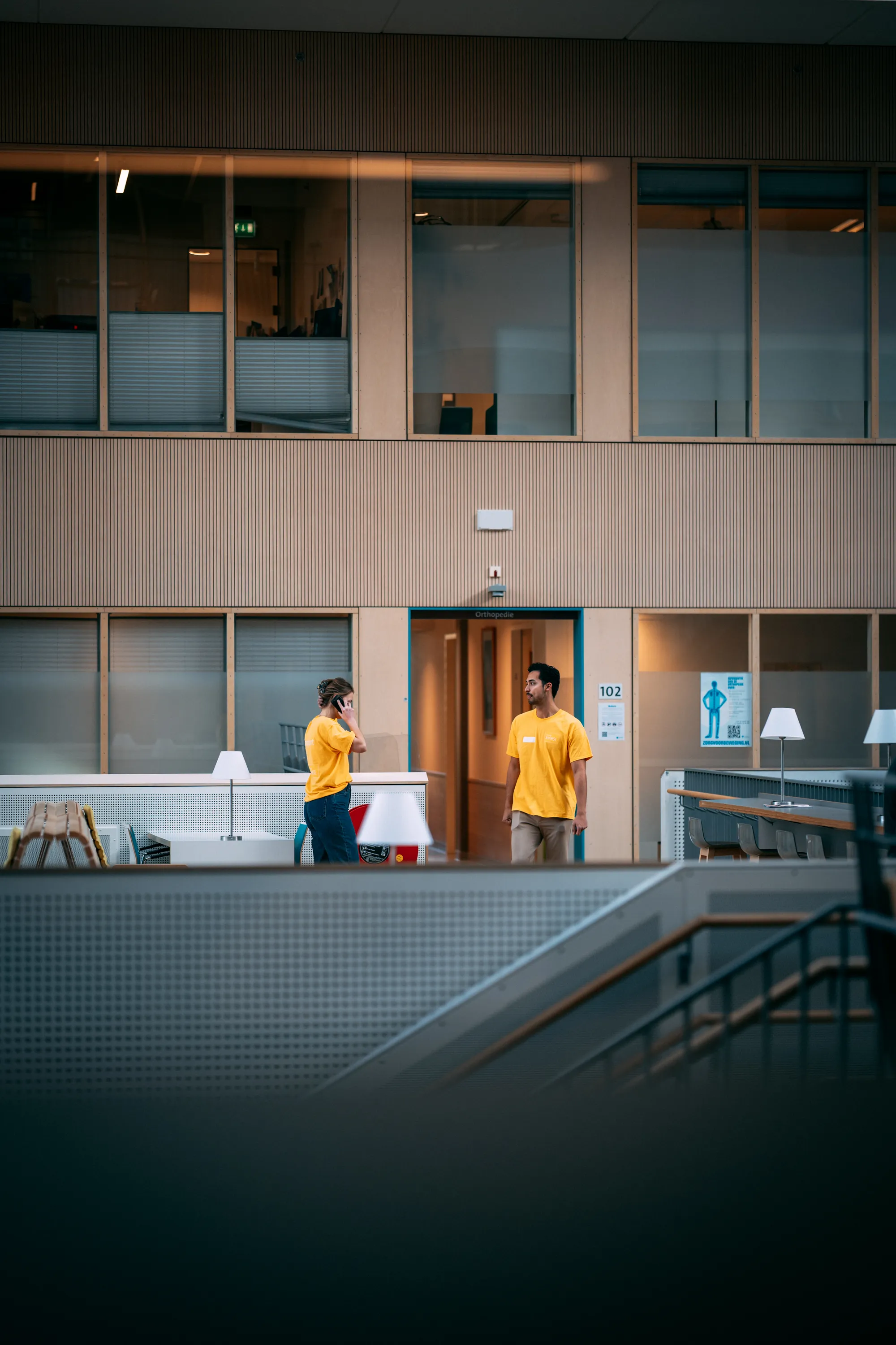Twee floorwalkers van Young KINASE in gele shirts bij de polikliniek tijdens een EPD go-live