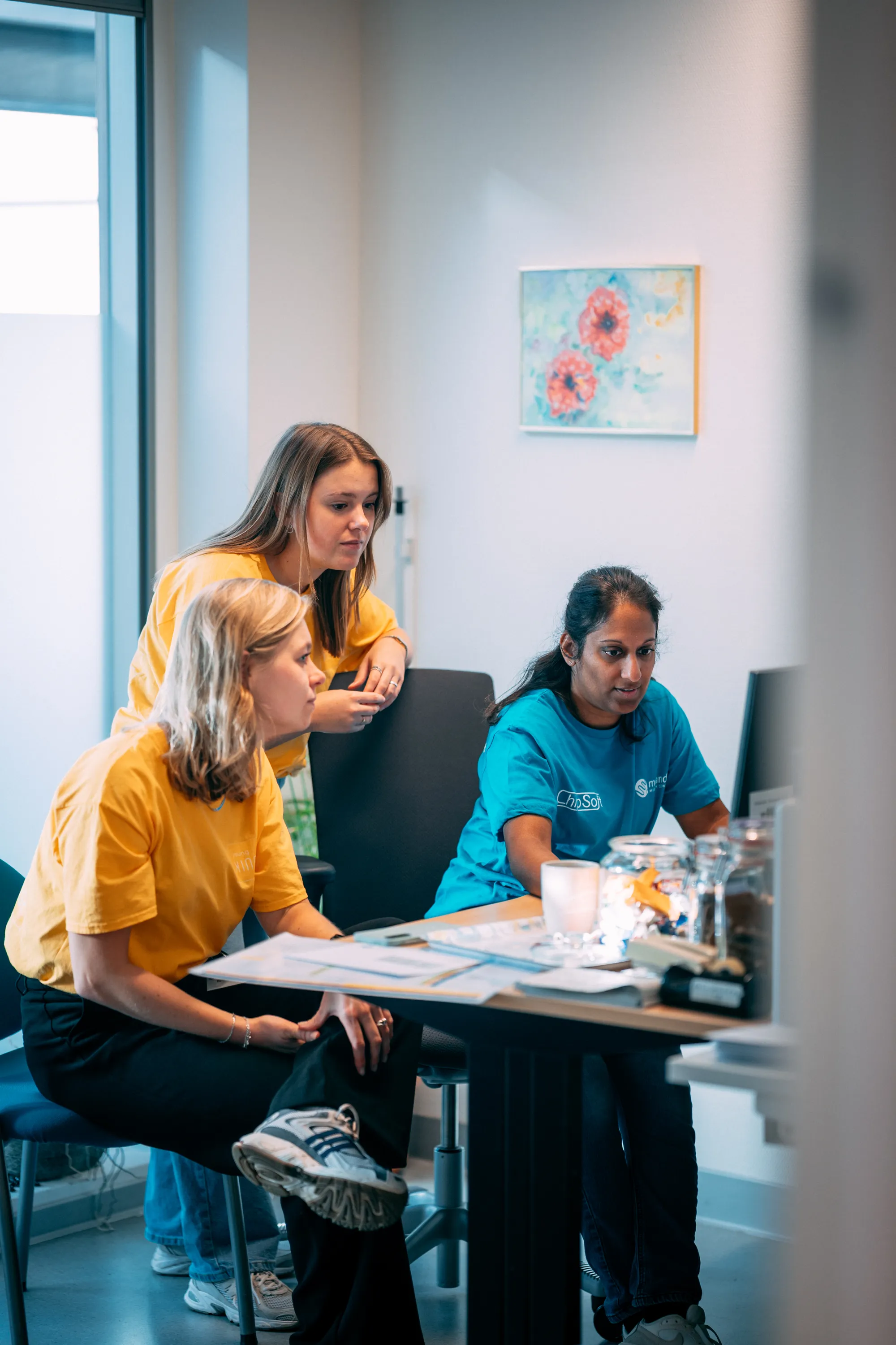 Floorwalkers van Young KINASE kijken mee bij het EPD-scherm tijdens een go-live
