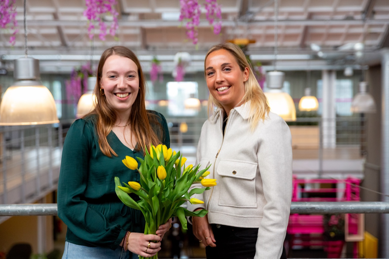 Kirsten Cornelisse van Young KINASE (rechts) met een collega van Ksyos, met een bos gele tulpen op het kantoor van Ksyos